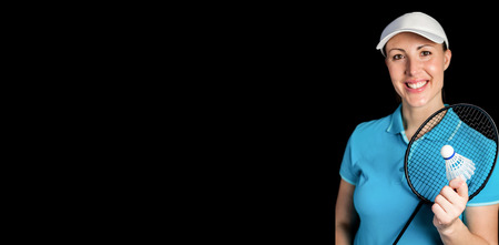 Happy badminton player holding badminton racket and shuttlecock on black backgroundの写真素材
