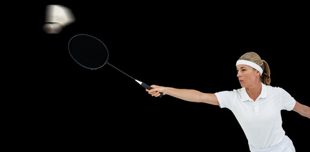 Female athlete playing badminton on black backgroundの写真素材