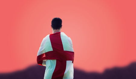Rear view of sportsman holding an England flag  against orangeの写真素材