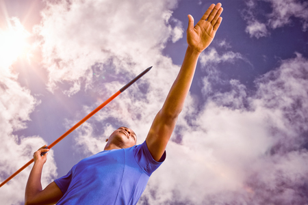 Low angle view of sportsman practising javelin throw  against bright blue sky with cloudsの写真素材