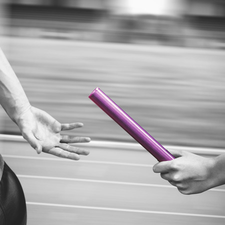 Athlete passing a baton to the partnerの写真素材