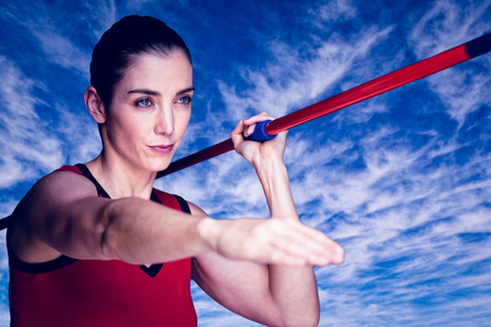 Female athlete throwing a javelin  against view of the blue skyの写真素材