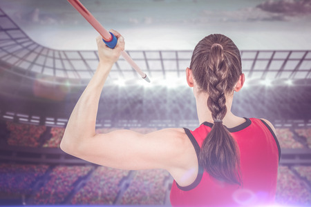 Female athlete throwing a javelin against race trackの写真素材