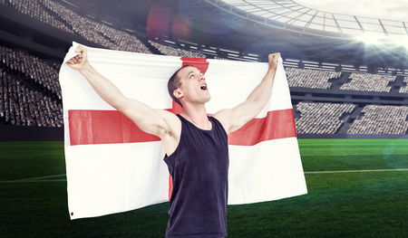 Athlete holding england national flag against rugby stadiumの写真素材