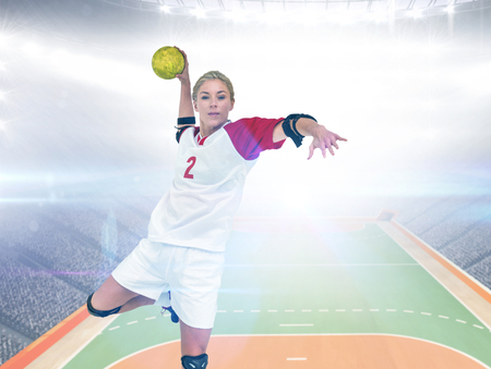 Sportswoman throwing a ball against handball field indoorの写真素材