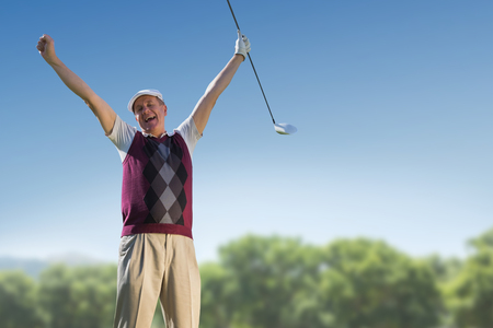 Golf player raising arms against park on sunny dayの写真素材