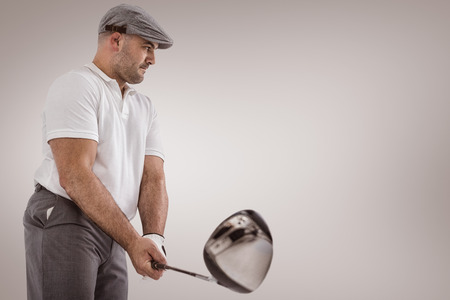 Golf player taking a shot against grey vignetteの写真素材