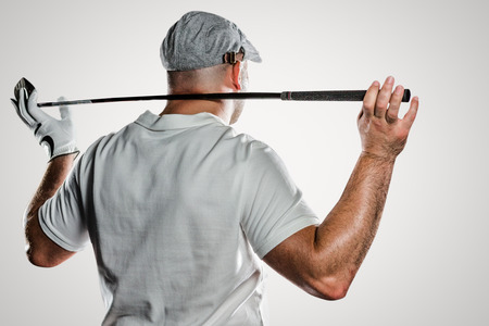 Rear view of golf player holding a golf club against grey backgroundの写真素材