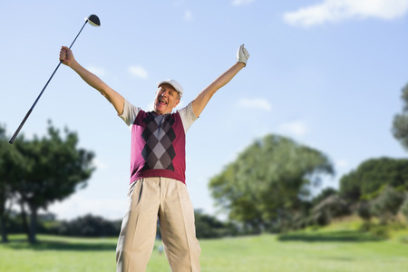 Golf player raising arms  against view of a parkの写真素材
