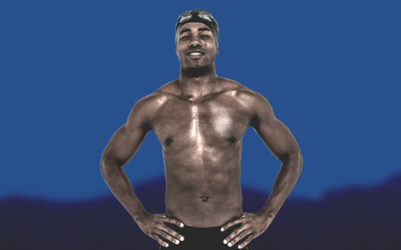 Swimmer smiling and posing  against blurred mountainsの写真素材