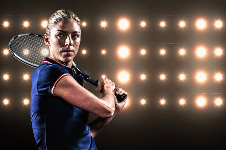 Tennis player playing tennis with a racket against composite image of orange spotlightの写真素材