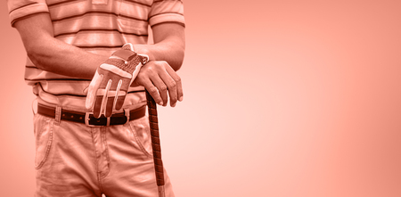 Man holding a golf club against orange backgroundの写真素材