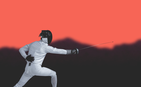 Man wearing fencing suit practicing with sword against blurred mountains