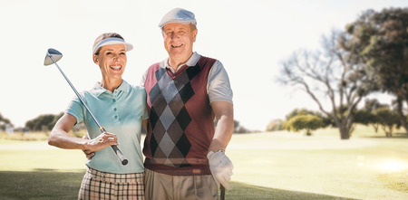 Couple golf players looking the camera  against view of a parkの写真素材