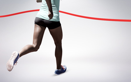 Rear view of sportswoman running on a white background against grey vignetteの写真素材