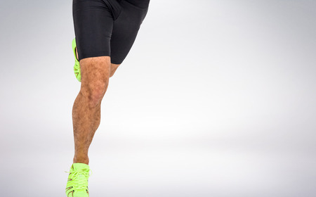 Male athlete running on white background against grey vignetteの写真素材