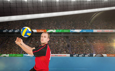 Sportsman posing while playing volleyball against view of a tennis fieldの写真素材