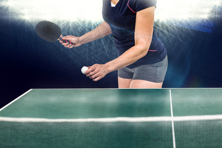 Composite image of female athlete playing table tennis against spotlightの写真素材