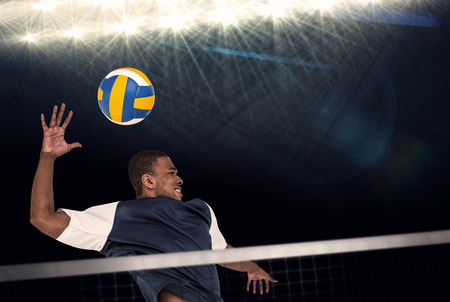 Composite image of sportsman playing volleyball against spot lightの写真素材