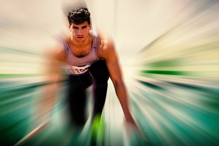 Composite image of sportsman waiting on the starting line against blurred backgroundの写真素材