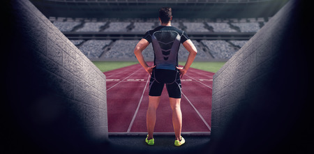 Composite image of athlete man posing with hands on hips in a stadiumの写真素材