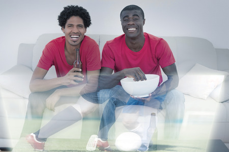 Composite image of friends are watching sport on television with beers at homeの写真素材