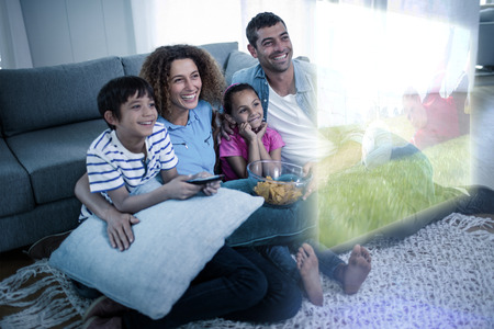 Composite image of family are watching sport on television at homeの写真素材