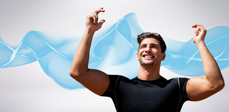 Portrait of happy sportsman  against blue wave