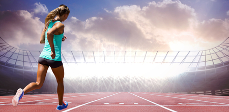 Rear view of sportswoman running on a white background against race trackの写真素材
