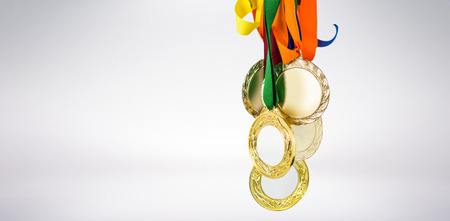 Athlete holding gold medals after victory on white backgroundの写真素材