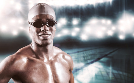 Composite image of swimmer standing with hand on hip against swimming poolの写真素材