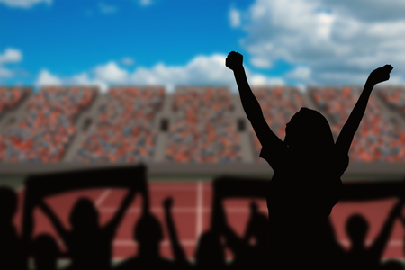 Silhouettes of football supporters against tennis field on a sunny dayの写真素材