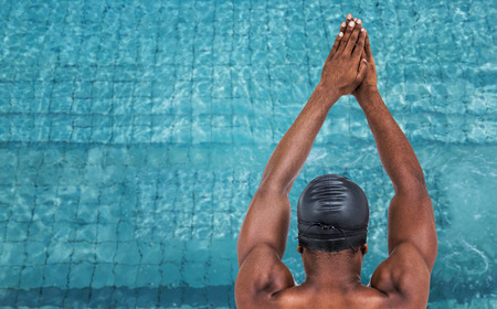 Rear view of swimmer ready to dive against view of  swimming poolの写真素材