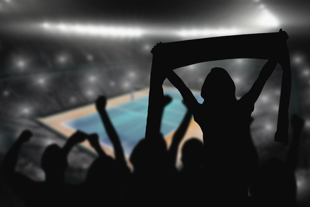 Silhouettes of football supporters against view of a tennis fieldの写真素材