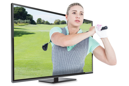 Pretty blonde playing golf against view of a landscape