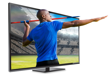 Profile view of sportsman practising javelin throw  against view of a stadium
