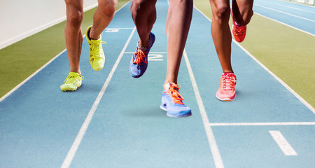 Close up of sportsman legs running against view of a running trackの写真素材