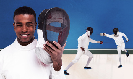 Swordsman holding fencing mask against digitally generated image of bicolored background