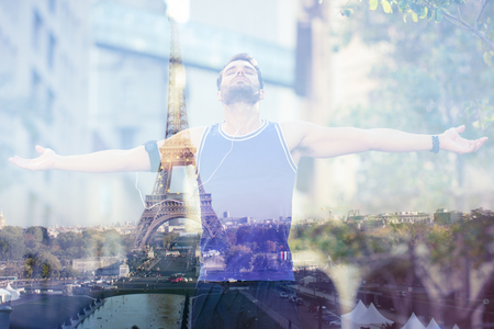 An handsome athlete enjoying the sun  against eiffel towerの写真素材