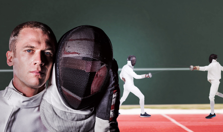 Close-up of swordsman holding fencing mask against digitally generated image of playing field