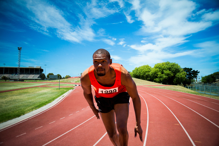 Handsome man preparing to start running against high angle view of trackの写真素材
