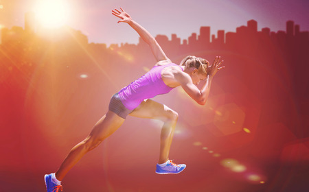 Athletic woman preparing to run against cityscape on sunlight