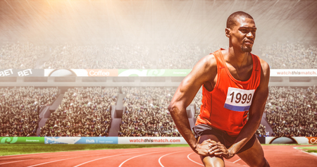 Front view of sportsman is stretching his muscles  against view of a stadiumの写真素材