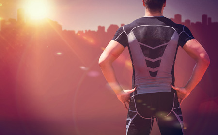 Rear view of athlete man posing against cityscape on sunlightの写真素材