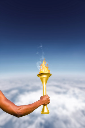 Rear view of sportsman holding a cup  against blue sky over white cloudsの写真素材