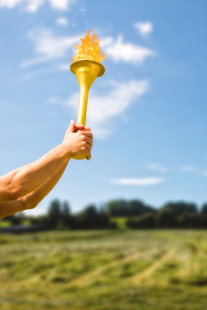 Low angle view of sportsman holding a cup  against green fieldの写真素材
