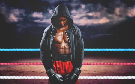 Boxer posing after failure against dark cloudy skyの写真素材