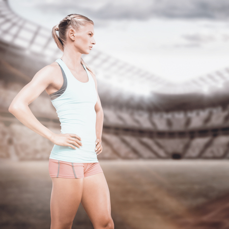Profile view of sportswoman standing on a white background against composite image of a stadiumの写真素材