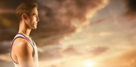 Side view of male athlete on black background  against view of an empty streetの写真素材
