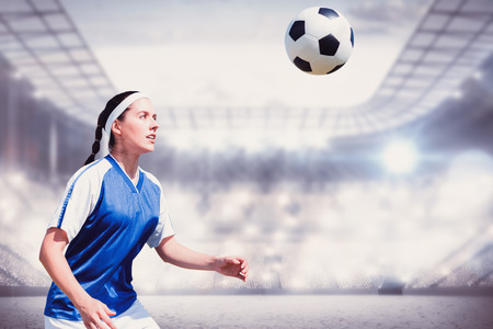Woman soccer player waiting the ball against sports arenaの写真素材